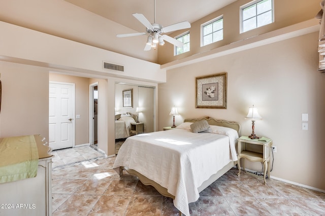 bedroom with a towering ceiling, ceiling fan, and a closet