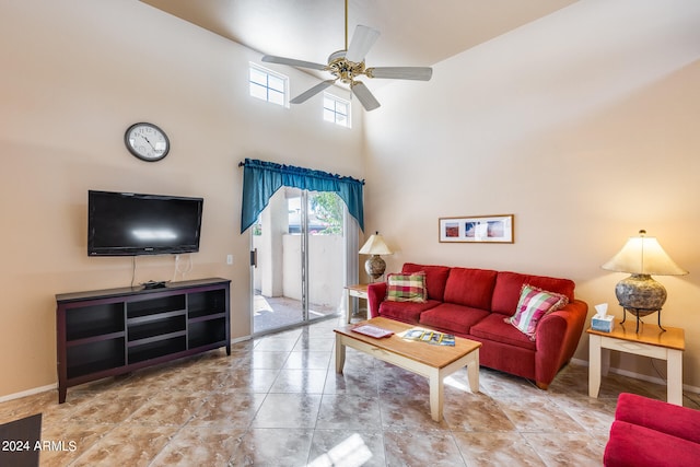 living room with a towering ceiling and ceiling fan