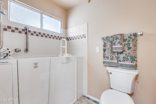 bathroom with washer / clothes dryer and toilet