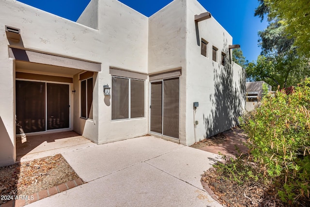 entrance to property featuring stucco siding and a patio