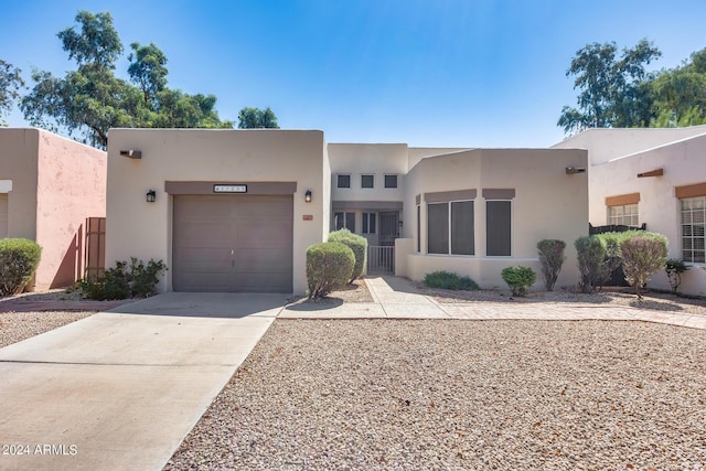 southwest-style home with stucco siding, a garage, and concrete driveway