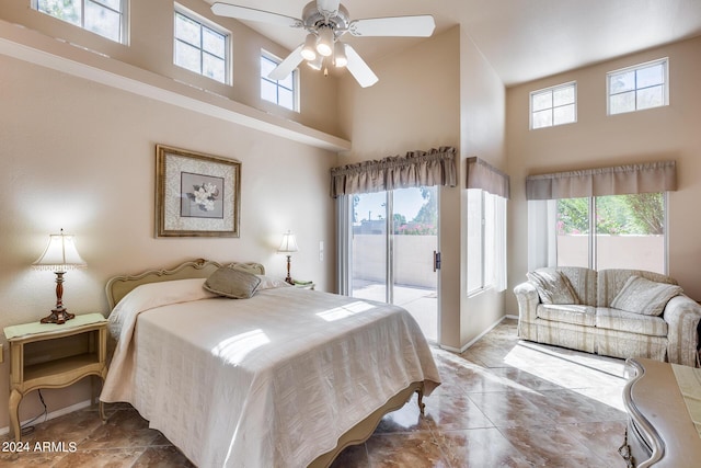 bedroom featuring a high ceiling, access to outside, a ceiling fan, and baseboards