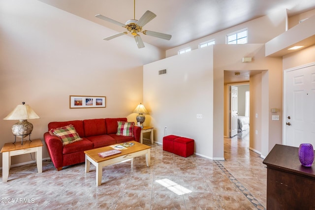 living area featuring visible vents, baseboards, a towering ceiling, and a ceiling fan