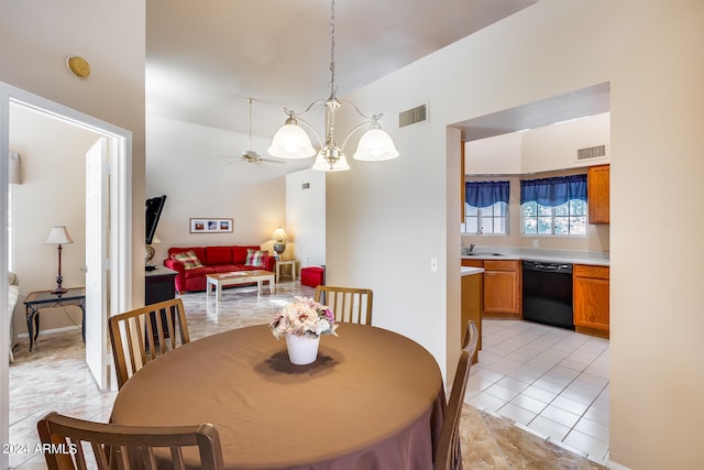 dining space with lofted ceiling, ceiling fan with notable chandelier, light tile patterned floors, and sink