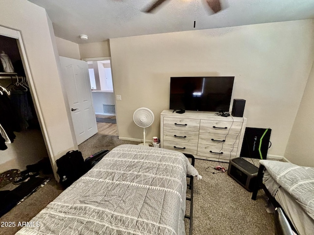 bedroom featuring dark colored carpet, ceiling fan, and a closet