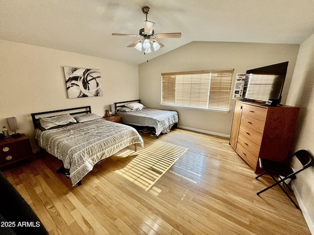 bedroom featuring ceiling fan, light wood-type flooring, and vaulted ceiling