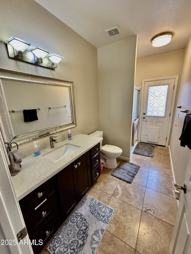 bathroom featuring vanity, a shower with door, tile patterned flooring, toilet, and a textured ceiling