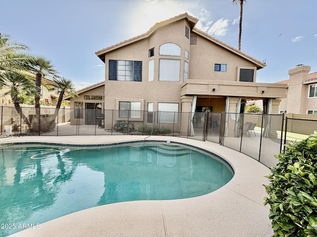 back of property featuring a fenced in pool