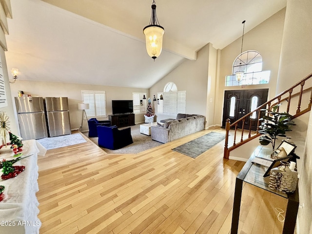 living room with hardwood / wood-style floors and high vaulted ceiling