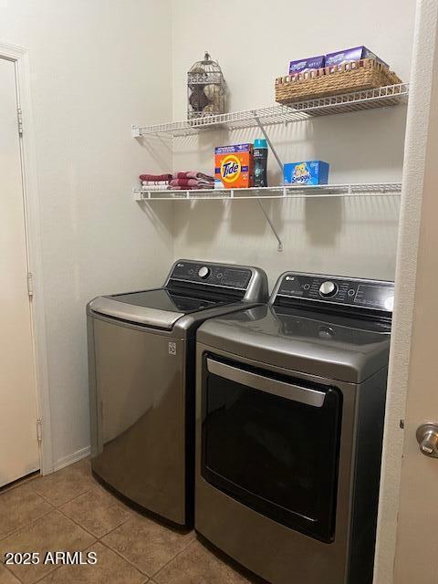 laundry room featuring laundry area, washing machine and clothes dryer, and tile patterned floors