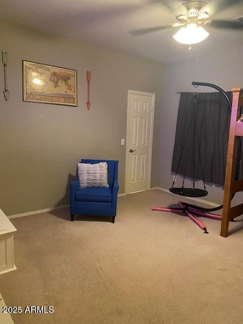 interior space with carpet floors, baseboards, and a ceiling fan