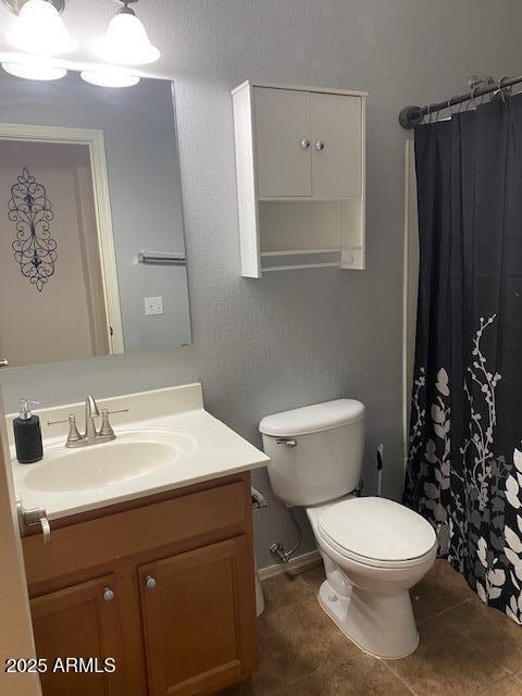 full bathroom featuring tile patterned flooring, a shower with curtain, vanity, and toilet