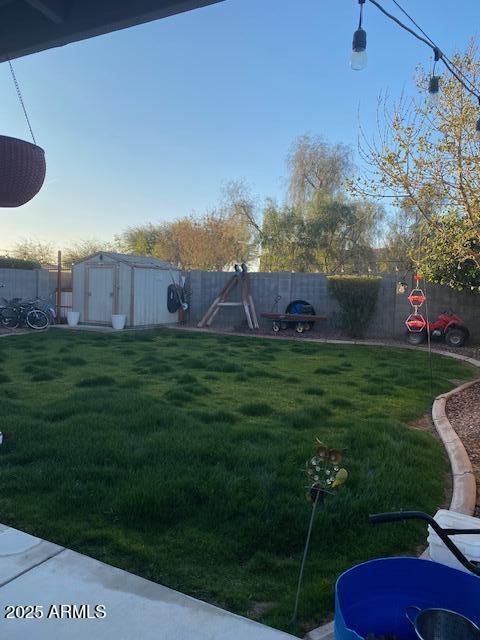 view of yard with an outbuilding, a shed, and a fenced backyard