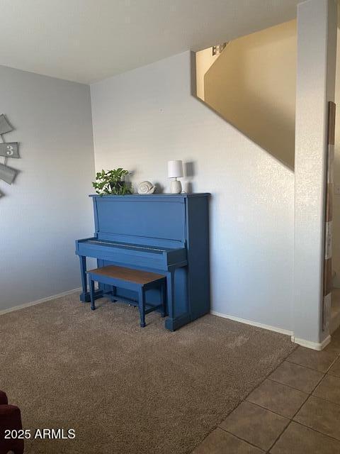 sitting room with dark tile patterned floors, dark carpet, and baseboards