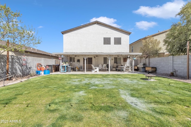 rear view of house with a yard, a patio, stucco siding, ceiling fan, and a fenced backyard