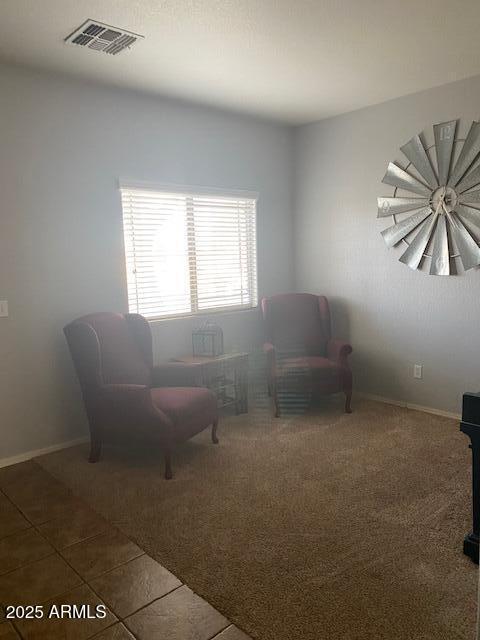 living area with tile patterned flooring, visible vents, and baseboards