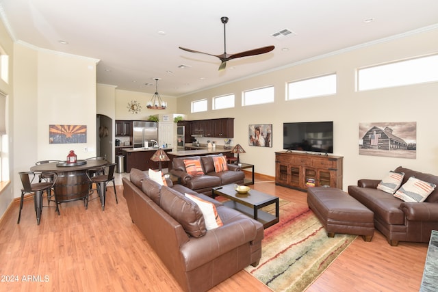 living room with light hardwood / wood-style floors, ceiling fan, and crown molding