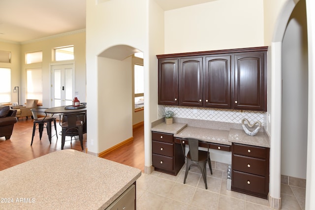 office area with a high ceiling, ornamental molding, and light hardwood / wood-style floors