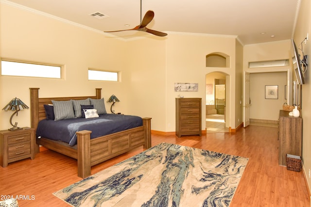 bedroom with wood-type flooring, connected bathroom, crown molding, and ceiling fan