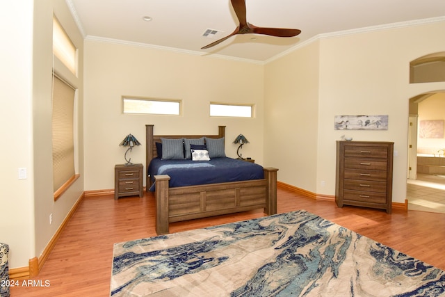 bedroom featuring hardwood / wood-style flooring, crown molding, ensuite bath, and ceiling fan