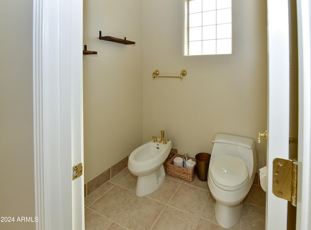 bathroom with a bidet, toilet, and tile patterned floors