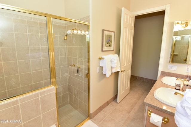 bathroom featuring a shower with shower door, tile patterned flooring, and dual bowl vanity