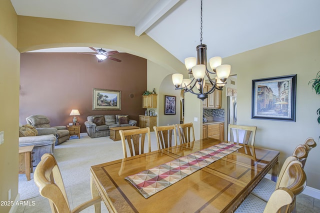 dining room featuring arched walkways, a chandelier, baseboards, and a ceiling fan