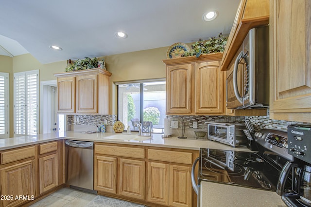 kitchen featuring appliances with stainless steel finishes, backsplash, light countertops, a sink, and recessed lighting