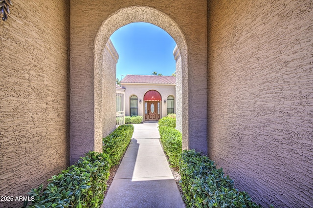 property entrance with stucco siding and a tiled roof