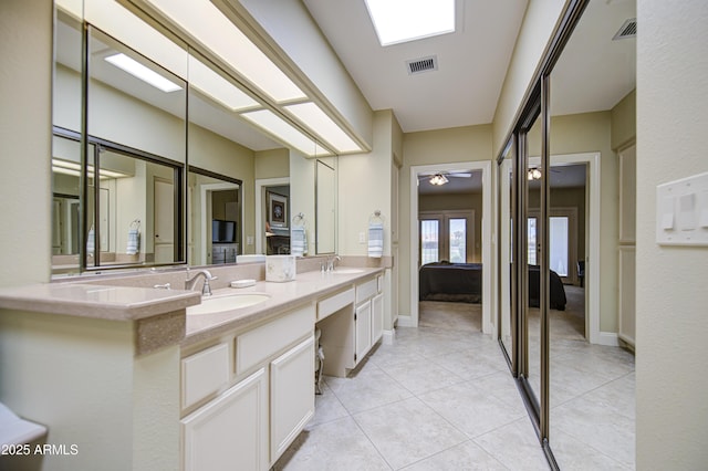 bathroom featuring double vanity, tile patterned floors, ensuite bathroom, ceiling fan, and baseboards