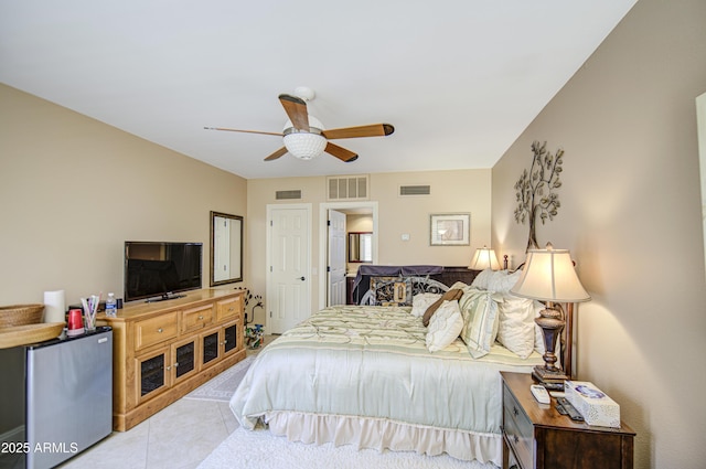 tiled bedroom featuring freestanding refrigerator and ceiling fan