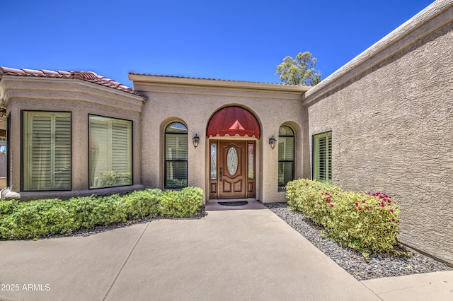 doorway to property featuring stucco siding