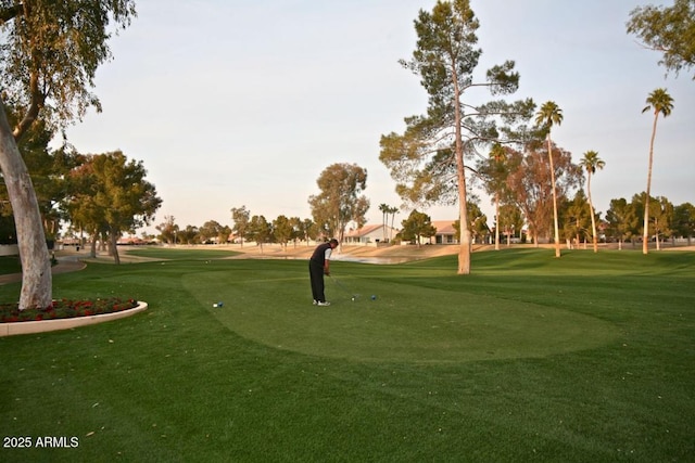 surrounding community with view of golf course and a lawn