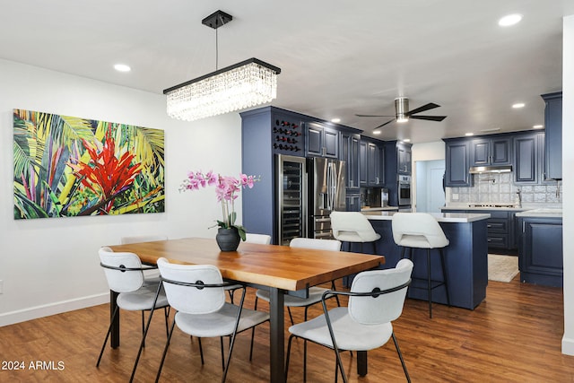 dining space featuring ceiling fan with notable chandelier and dark hardwood / wood-style flooring