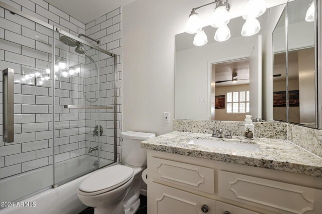 bathroom featuring tile patterned flooring, toilet, vanity, and a shower with shower door