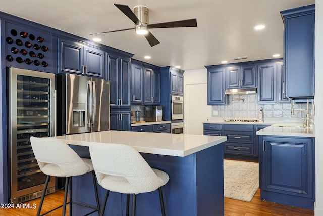 kitchen with sink, dark wood-type flooring, a kitchen island, and a kitchen bar