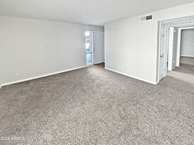 carpeted spare room with baseboards and visible vents