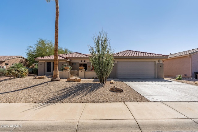 mediterranean / spanish house featuring a garage, stucco siding, driveway, and a tiled roof