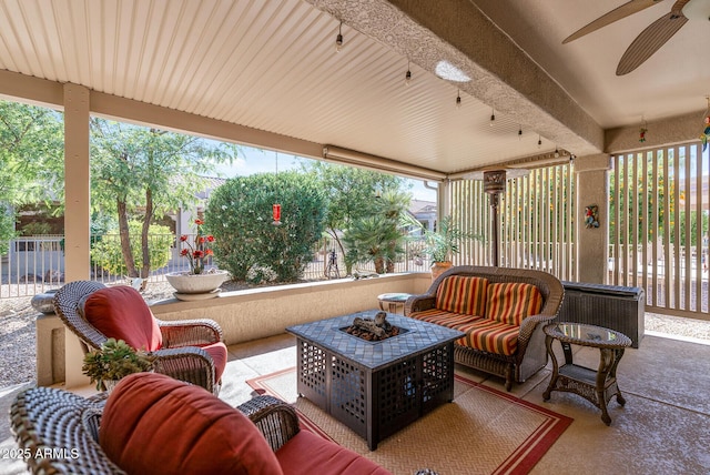 view of patio with a ceiling fan, an outdoor living space with a fire pit, and fence