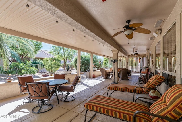 view of patio featuring fence, a ceiling fan, outdoor dining space, and visible vents