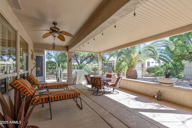 sunroom with visible vents, a ceiling fan, and outdoor dining area