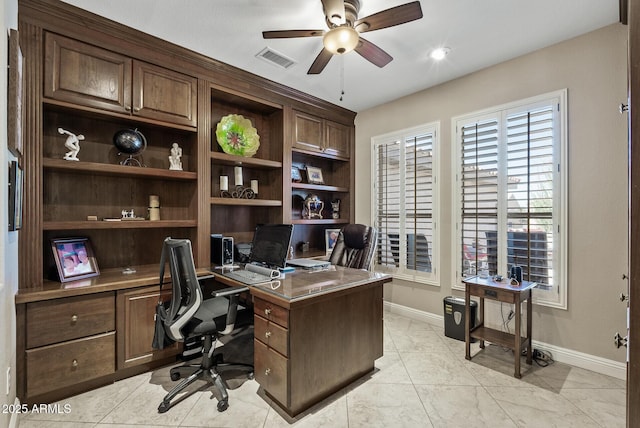 office area with visible vents, a ceiling fan, baseboards, and built in desk