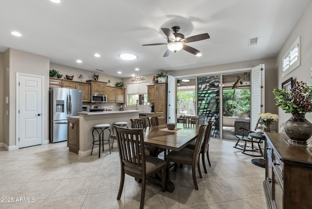 dining area with a wealth of natural light, a ceiling fan, light tile patterned flooring, and visible vents