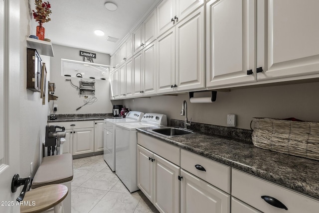 laundry room with cabinet space, light tile patterned floors, washing machine and dryer, and a sink
