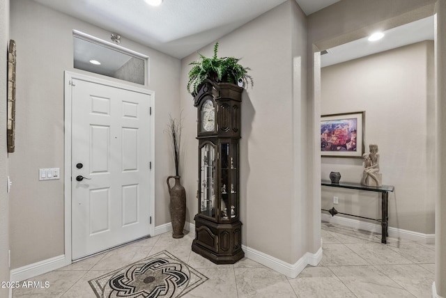 foyer with baseboards and recessed lighting