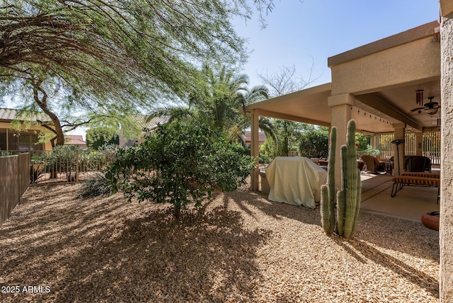 view of yard featuring a fenced backyard, ceiling fan, and a patio area