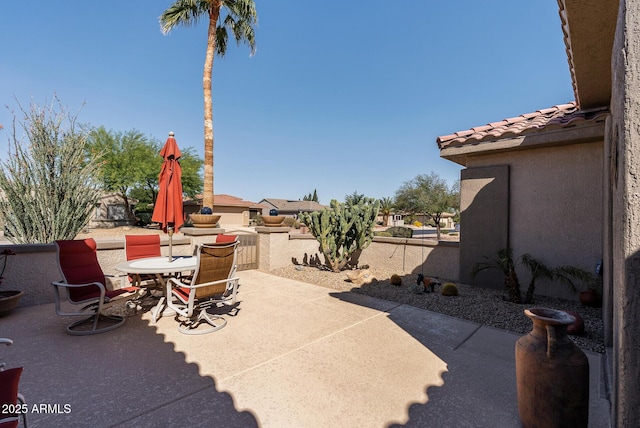 view of patio featuring outdoor dining area and fence