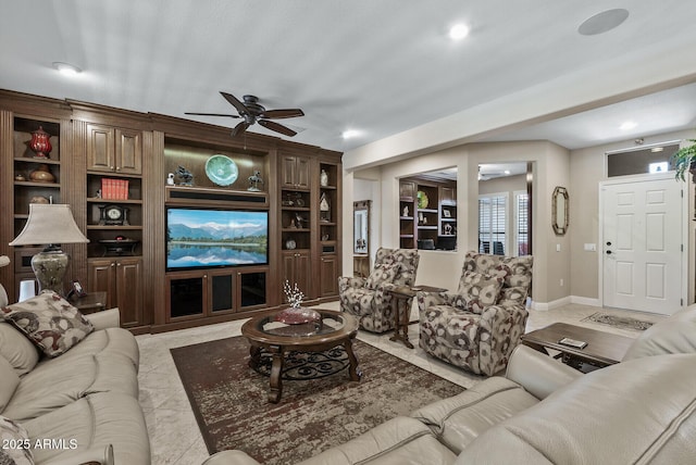living room with light tile patterned floors, baseboards, ceiling fan, and built in shelves