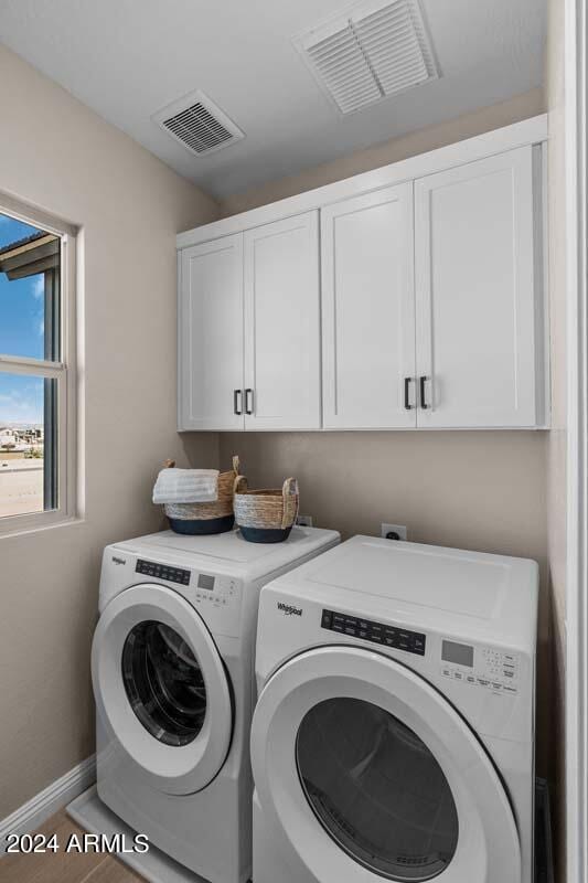 laundry area featuring cabinets and washer and clothes dryer