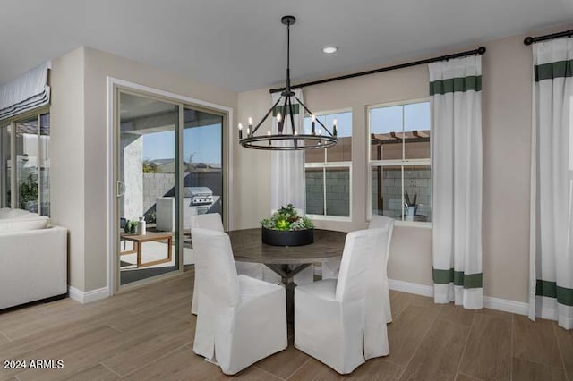 dining room with light hardwood / wood-style flooring and a notable chandelier